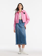 A lady wears a skirt and a crop top.